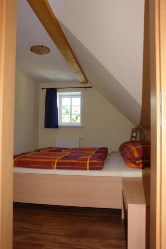 a bedroom with a bed and a window at Räucher-Häusl in Herrnhut