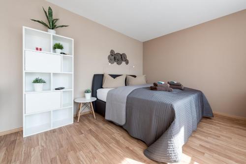 a bedroom with a bed and white shelves at Boutique Apartments Kirchzarten in Kirchzarten
