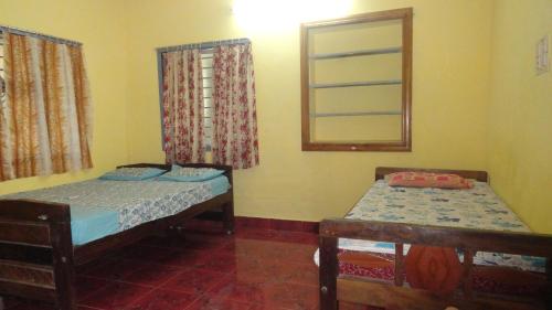 a small room with two beds and a mirror at Naga Palace in Gokarna