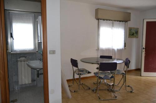 una cucina con tavolo e sedie in una stanza di Bilocale Rivazzurra a Rimini