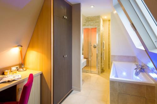 博姆雷達姆的住宿－阿斯堡酒店，浴室配有盥洗盆和浴缸。