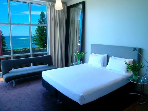 a bedroom with a large white bed and a window at Dive Hotel in Sydney