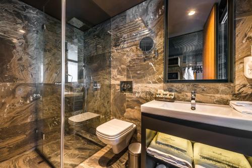 a bathroom with a sink, toilet and bathtub at All Seasons Residence Hotel in Sofia