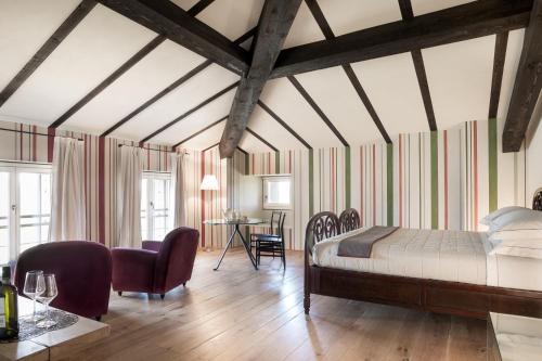 a bedroom with a bed and a table and chairs at Locanda La Raia in Gavi
