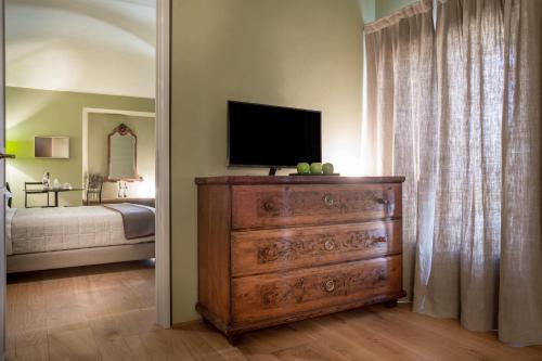 a bedroom with a dresser with a television on it at Locanda La Raia in Gavi