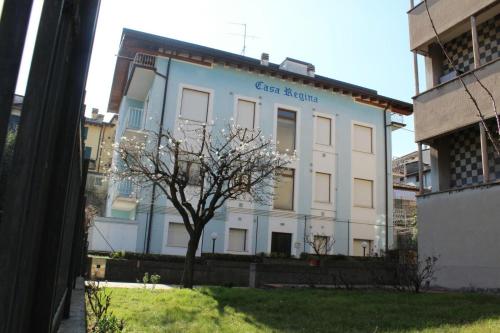 a white building with a tree in front of it at Casa regina in Desenzano del Garda