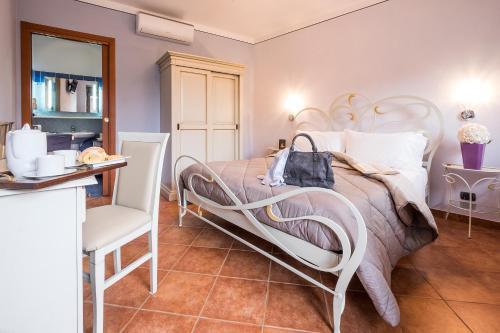 1 dormitorio con 1 cama blanca y 1 silla en Costa Catterina B&B, en Castagnito