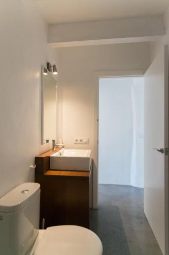 a bathroom with a white toilet and a sink at Curniola in Ciutadella