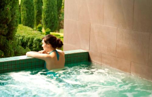 a woman in a bathing suit in a pool of water at Peppers Mineral Spring Hotel Hepburn in Hepburn Springs