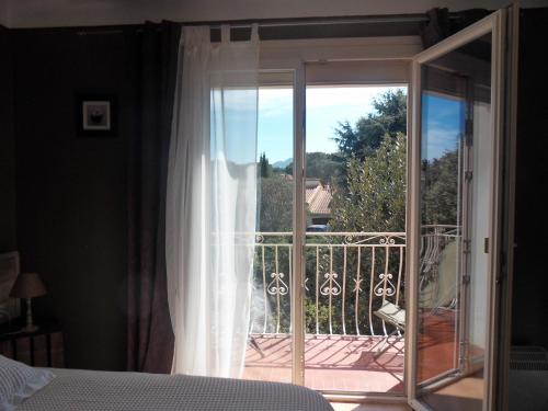 a bedroom with a sliding glass door to a balcony at Chambres d'Hôtes de la Grone in Argelès-sur-Mer