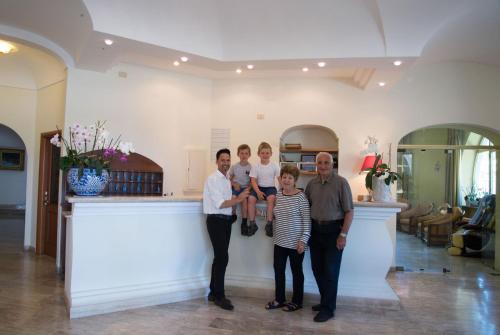 a group of people posing for a picture in a kitchen at Hotel Internazionale in Ischia