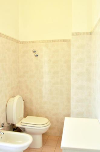 a bathroom with a white toilet and a sink at B&B Gulliver in Noto