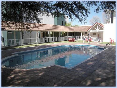 a swimming pool in front of a house at Hotel Lihuel Calel in Santa Rosa