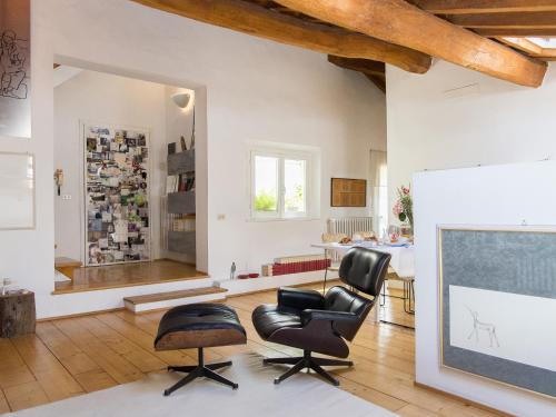 un soggiorno con 2 sedie e uno schermo per proiezione di Stella21 BedandBreakfast a Modena
