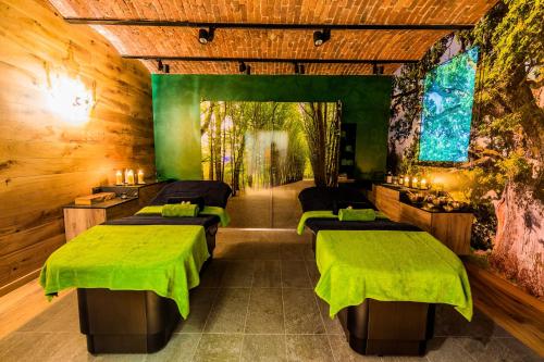 a room with four beds with green sheets at Hotel Dębowy Biowellness & SPA Góry Sowie in Bielawa