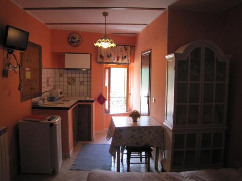 a kitchen with orange walls and a table and chairs at Maison Dina in Collepardo