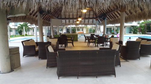 a restaurant with chairs and tables and a pool at Villa Perfecta Zona Diamante in Acapulco