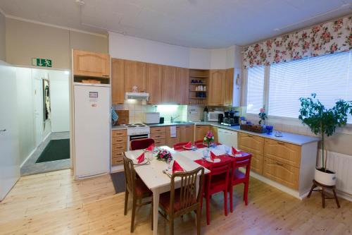 una cocina con una mesa con servilletas rojas. en Matkustajakoti Kuutamo Guesthouse, en Suomussalmi