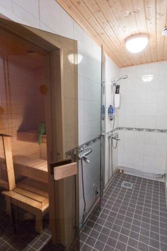 a bathroom with a shower and a bench in it at Kuutamo B&B Guesthouse in Suomussalmi