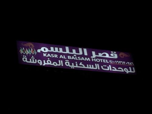 a purple and white sign that reads kasha al basrahim hospital at Qsr Al Balsem Aparthotel in Unayzah
