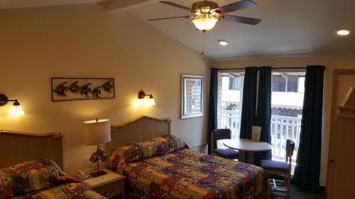 a hotel room with a bed and a table and a window at Atlantic Motel in Point Pleasant Beach