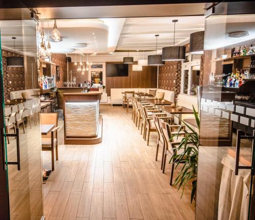 a restaurant with tables and chairs and a bar at Penzion Panda in Turčianske Teplice