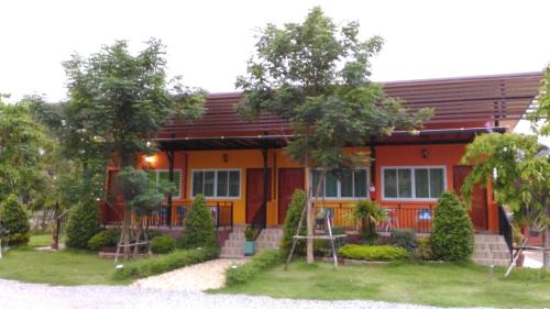 a red and orange house with trees in front of it at Navy Sisatchanalai in Ban Nong Chang