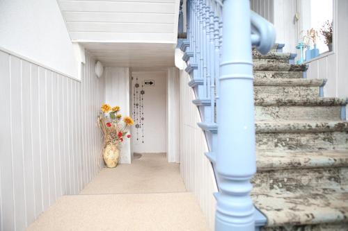 einen Flur mit Treppen und einer Vase voller Blumen in der Unterkunft Ferienwohnung TINA in Naumburg