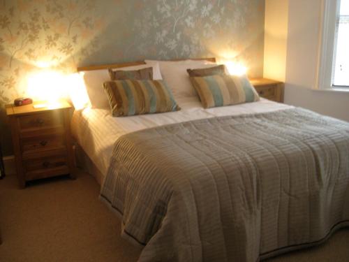 um quarto com uma cama grande e 2 candeeiros em Taylors Guesthouse em Salisbury