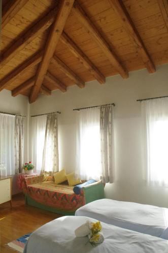 a bedroom with two beds and windows with curtains at Osteria La Pesa in Ponzano Veneto