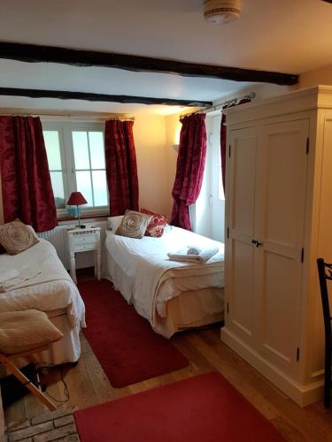 a bedroom with two beds and a red rug at The Brambles B&B in Waterbeach