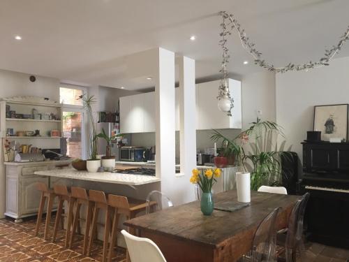 a kitchen and dining room with a wooden table and chairs at B&B Le Chat Qui Dort in Montricoux