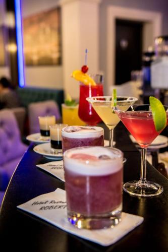 a table with several cocktails and glasses on it at Hotel Roberto Slanic Prahova in Slănic