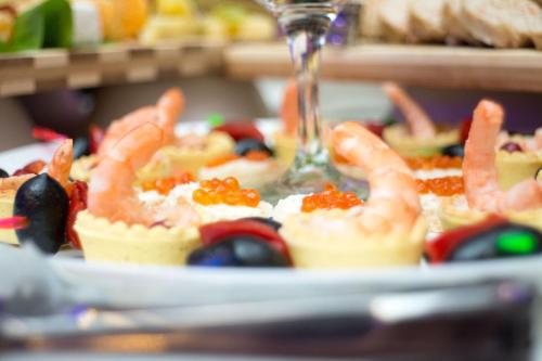 a plate of food with shrimp and fruit on it at Hotel Roberto Slanic Prahova in Slănic