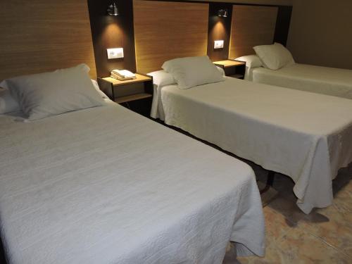 a hotel room with two beds and two night stands at Cruceiro do Monte in Tui