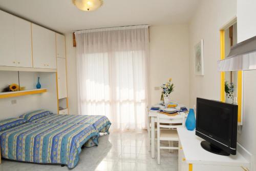 1 dormitorio con 1 cama y escritorio con TV en Residence Joker, en Cavallino-Treporti