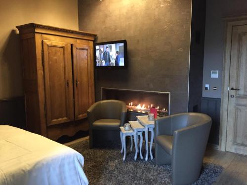a bedroom with a fireplace and a bed and a table and chairs at B&B De Rentmeesterhoeve in Reningelst