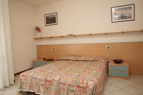 カヴァッリーノ・トレポルティにあるVillini Joker ai Frassiniのベッドルーム1室(ベッド1台、木製ヘッドボード付)