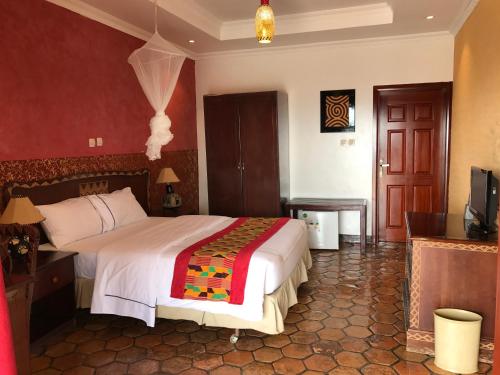 a bedroom with a bed and a television in it at Inside Afrika Boutique Hotel in Kigali