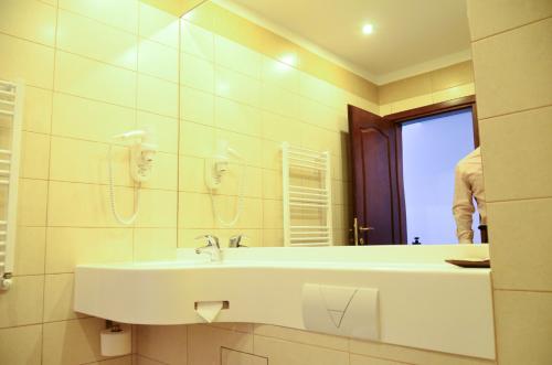 uma casa de banho com um lavatório e um espelho em Hotel Miraj em Râmnicu Vâlcea