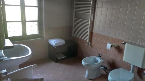 un bagno con wc, bidet e lavandino di Villa Asiola a Villa Vicentina