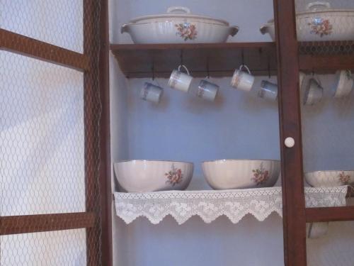 a shelf with bowls and cups on a wall at Casa da Tita in Salir