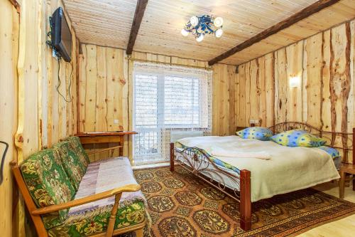 um quarto com uma cama e um sofá num quarto em Gutsulska rodzynka em Yaremche