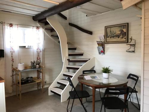 a room with a staircase with a table and chairs at Prinsgården B&B rum stugor in Mora