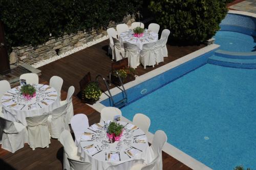 a group of tables and chairs next to a pool at Archontiko Naoumidi in Portariá