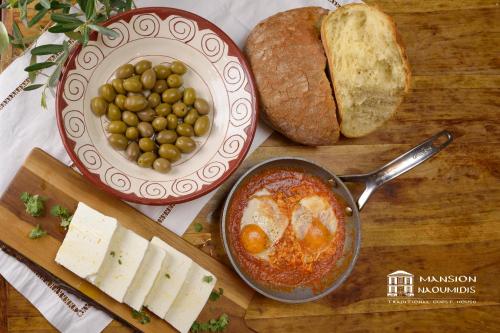 a table with a bowl of food and a plate of eggs and bread at Archontiko Naoumidi in Portariá