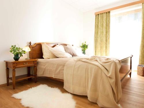 ein Schlafzimmer mit einem Bett und einem Tisch mit einem Teppich in der Unterkunft Brandtner Komfortzimmer in Kaumberg