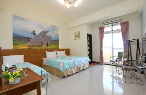 een slaapkamer met een bed, een bureau en een tafel bij Sweet Home in Taitung in Taitung