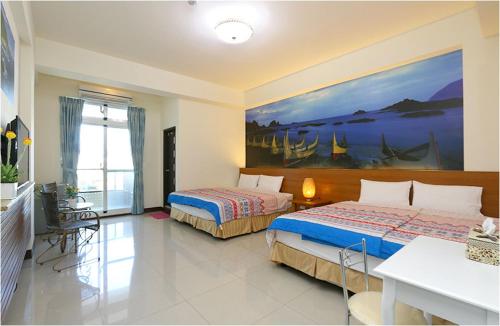 een slaapkamer met 2 bedden en een schilderij aan de muur bij Sweet Home in Taitung in Taitung