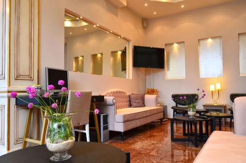 a living room with a couch and a table with flowers at Olympic Hotel in Parga